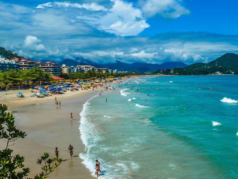 Vista panorâmica da Praia Grande em Ubatuba com mar cristalino e moradas ao fundo